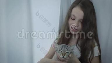 美丽的小女孩轻轻地<strong>与你</strong>心爱的猫在窗口交流。